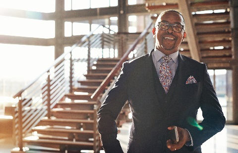 Businessman standing indoors holding smart phone